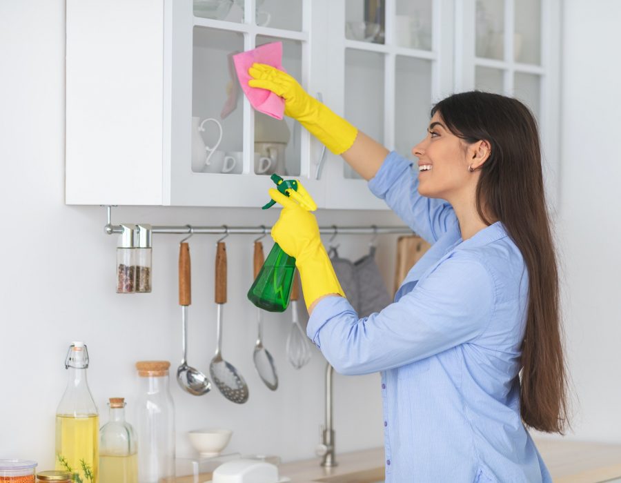 young-woman-cleaning-shelfs-at-home-at-kitchen.jpg